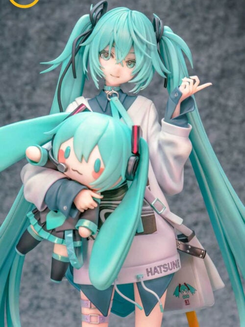 Close-up of Hatsune Miku's face, raised hand and the Miku doll in her arm, showing the doll's headset and pleated skirt.