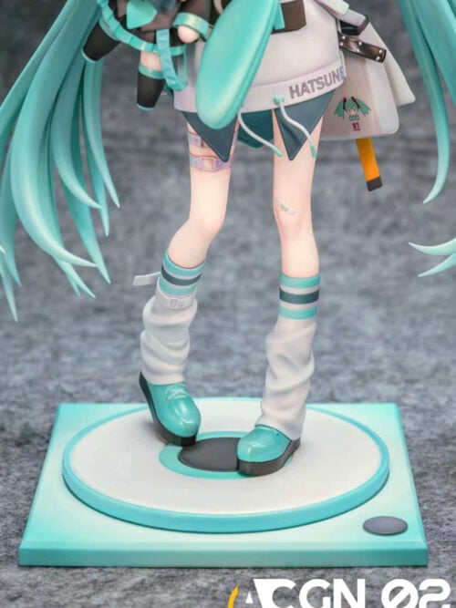 Detail of Hatsune Miku's loose pale leg warmers and turquoise platform shoes above a circular platform on a square teal base.