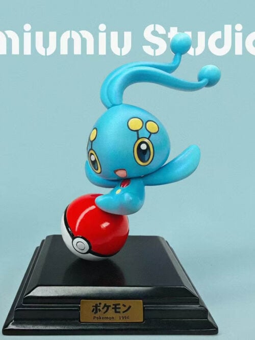 cfs004414 01 Manaphy with curved antennae and outstretched arms above a tilted Poké Ball on a stepped black base with a gold-colored plaque.