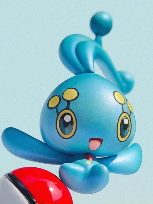 Angled close-up of Manaphy's smiling face, yellow eye markings and spread arms, with part of the red-and-white Poké Ball visible.