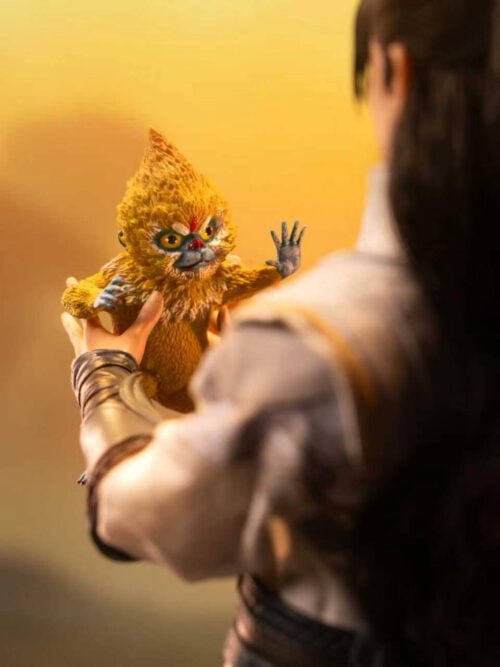 Over-the-shoulder view of Han Li holding the golden-furred Ti Hun companion, with its face and raised hand visible.