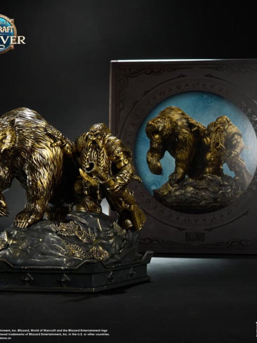 Bronze-colored dwarf hunter and bear statue on a rocky base, displayed in front of its illustrated product box.
