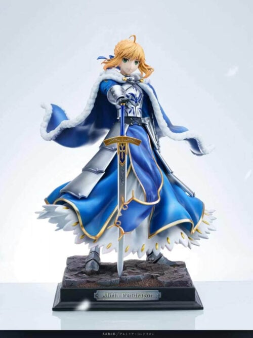 Altria Pendragon statue with a downward-pointing sword, white-trimmed blue cloak and silver armor on a rectangular stonework base.