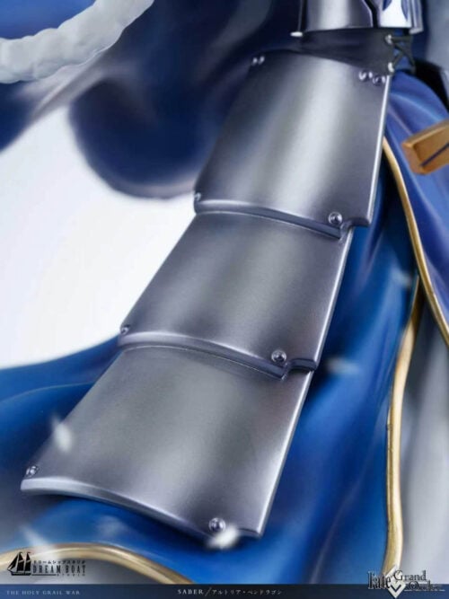Close-up of overlapping silver-colored hip armor plates with rivet details over Altria Pendragon's blue and gold-edged dress.