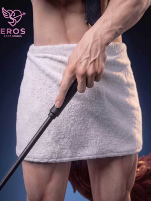 Close-up of Valko's hand holding a black riding crop in front of a textured white bath towel.