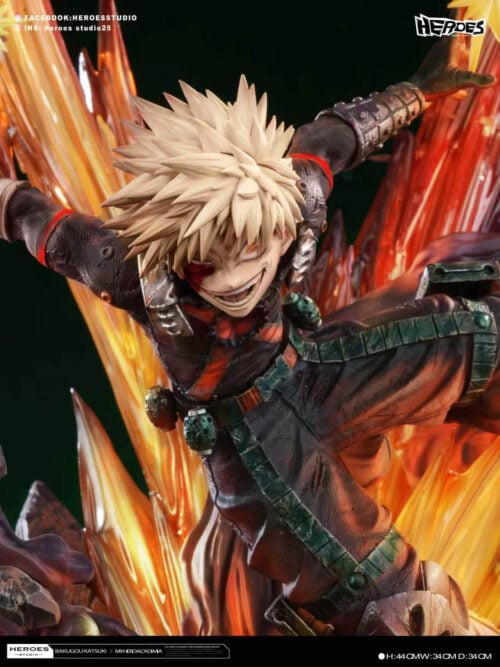 Close-up of Katsuki Bakugo's spiky blond hair, broad grin, marked face and scuffed black-and-orange costume.
