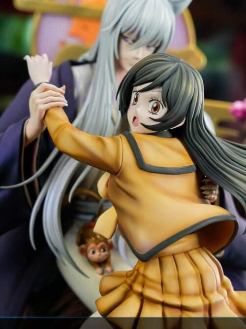 Close-up of Nanami's smiling face, flowing dark hair and yellow school uniform, with long-haired Tomoe and pink blossoms behind her.
