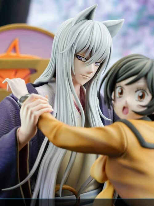 Close-up of Tomoe's long silver hair, fox ears and purple eyes beside Nanami's smiling face and outstretched arm.