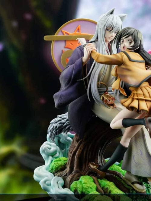 Tomoe and Nanami diorama with inset close-ups of a small monkey-like figure, Tomoe's tail, and tree roots beside Nanami's shoe.