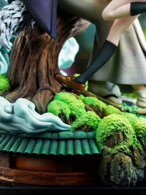 Close-up of the diorama base showing tree roots, moss-covered rocks, pale-blue curling effects and a green tiled roof detail.