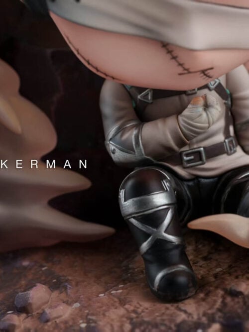 Detail of Levi Ackerman's wrapped fist, uniform harness, black boots and pale smoke above the textured rocky ground.