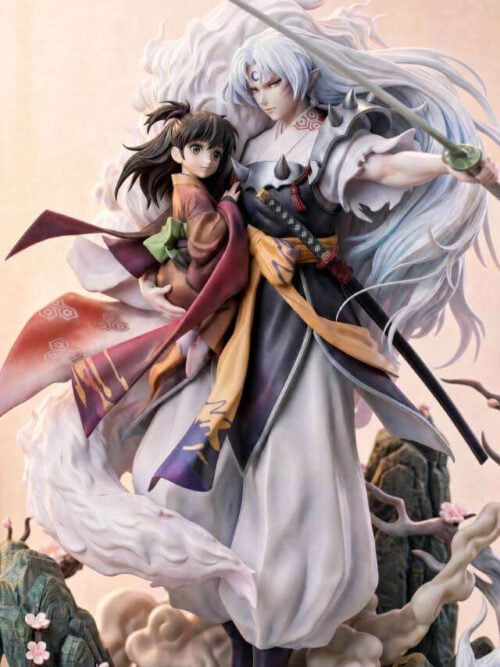 Close view of Sesshomaru and Rin showing their faces, his crescent forehead marking and spiked armor, and her warm-toned kimono.