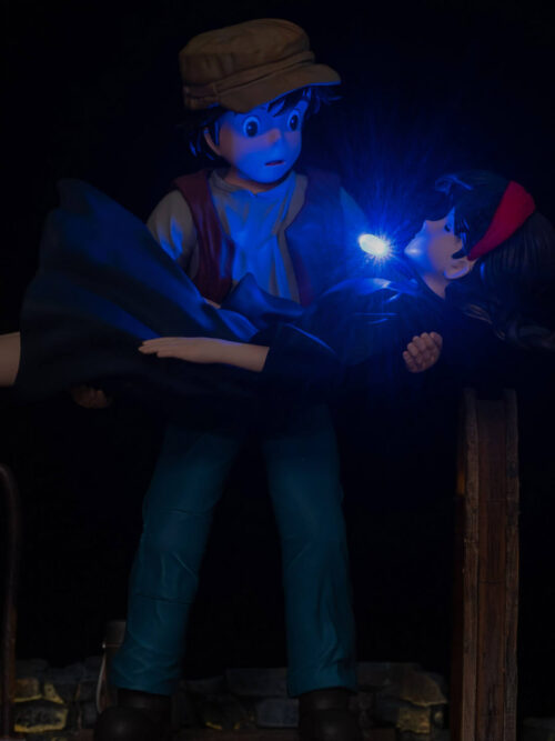 Sheeta's blue pendant illuminates her face and Pazu's face in a dark close-up of the music box figures.