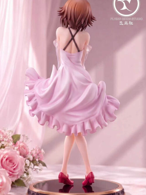 Rear view of Chisa Kotegawa showing crossed dark dress straps, sweeping pink ruffles, red shoes and a gold-trimmed round base.