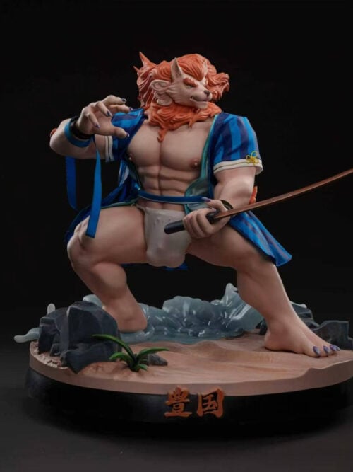 Toyokuni statue in a blue-striped haori and white loincloth, holding a sword above a sandy base with rocks and waves.