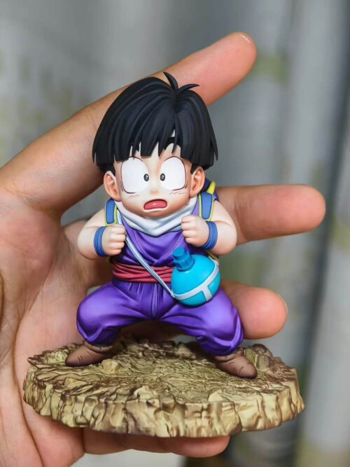 Handheld front view of the Son Gohan prototype with wide eyes, an open mouth, purple clothing and a rocky base.