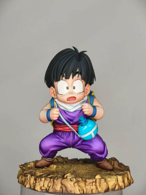 Son Gohan prototype against a gray background, gripping backpack straps above a red sash, purple trousers and rocky base.