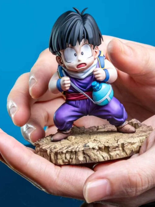 Son Gohan prototype and rocky display base held in two hands, showing the purple outfit, backpack straps and turquoise canteen.