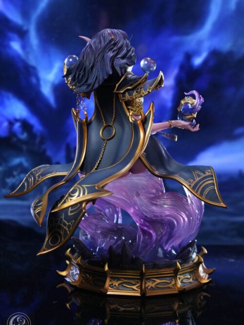 Rear view of Xal'atath showing layered purple hair, gold-edged blue costume panels, hanging chains, purple effects and the display base.
