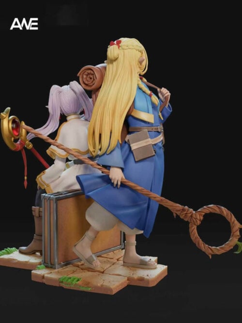 Reverse three-quarter view showing Marcille's long blonde hair and looped wooden staff beside Frieren seated on a travel case.