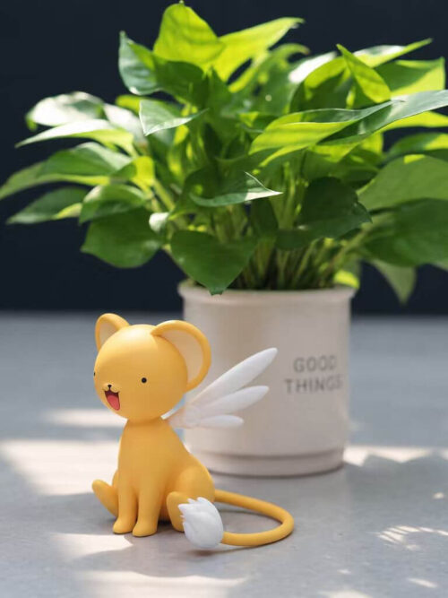 Wide view of LD Studio's Kero figure beside a potted plant, showing the seated pose, white wings and long curved tail with a white tuft.