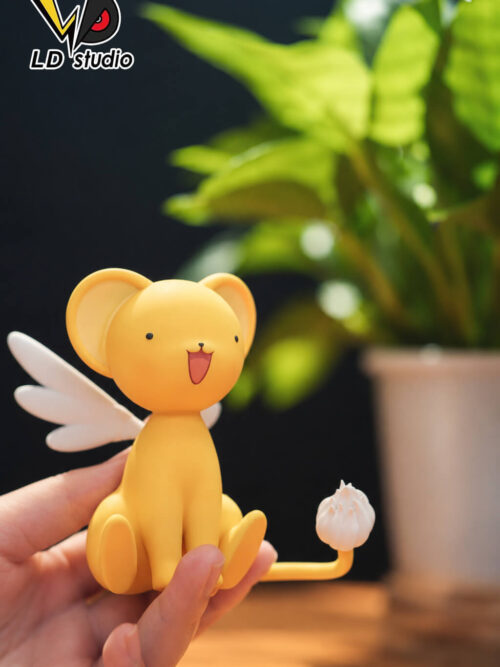 Three-quarter view of LD Studio's Kero figure supported by a hand, with a smiling face, white wing and upturned white-tufted tail.