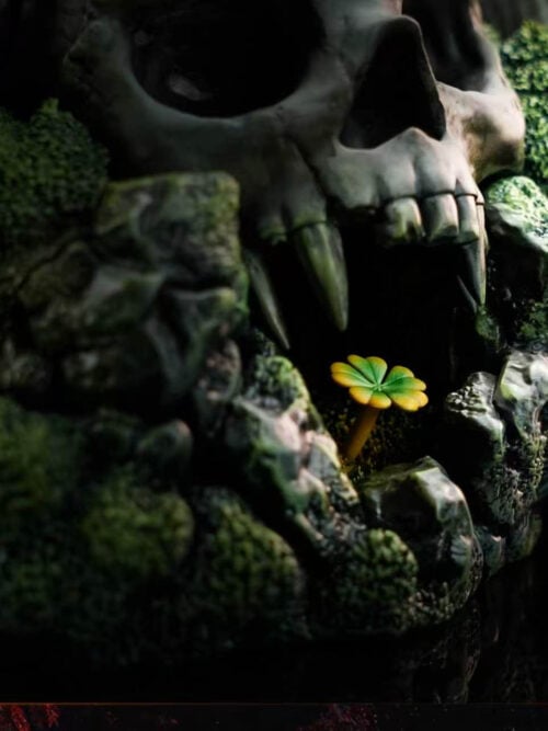 Close-up of the skull base with long fangs, moss-covered rocks and a small yellow-green clover beneath the jaw.