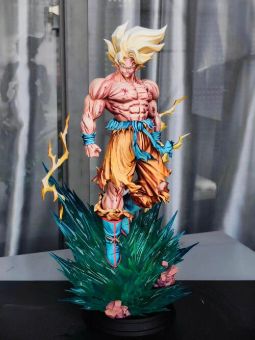 Son Goku statue with swept-up golden hair and torn orange trousers, hovering above a teal energy base with yellow lightning effects.