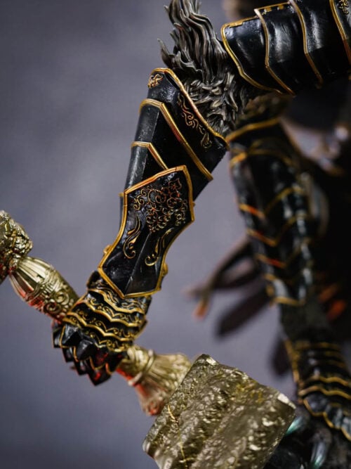Close view of Maliketh's gold-trimmed black forearm armor and hand gripping the ornate sword hilt.