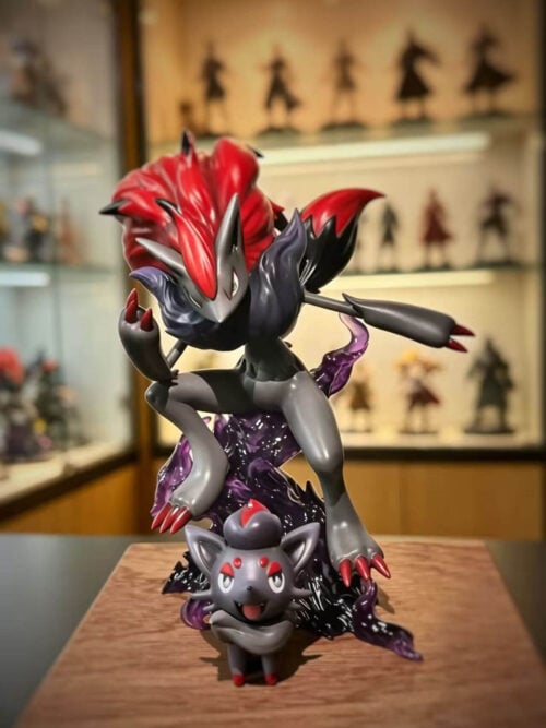 Zoroark crouching above a translucent purple effects base, with its red mane swept back and a smiling Zorua in front.