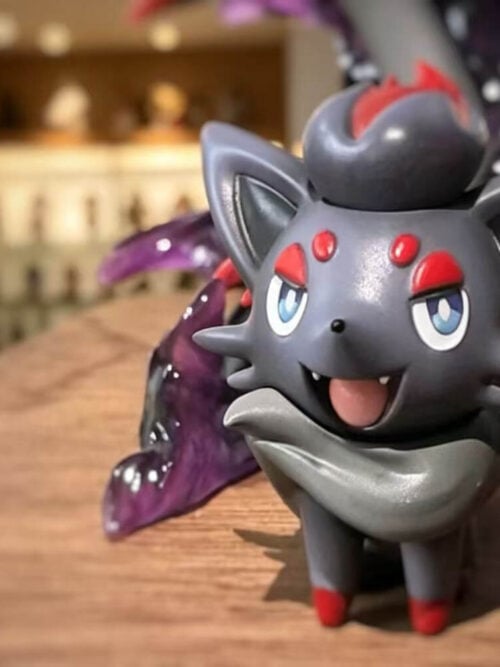 Close-up of Zorua with blue eyes, red forehead markings and an open-mouthed smile, with purple effects behind it.