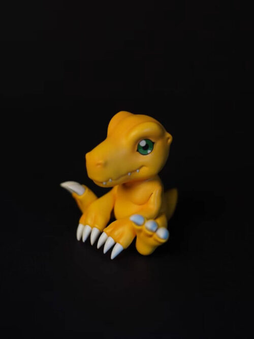 Three-quarter view of seated Agumon facing left, showing its green eye, white claws and tail behind the body.