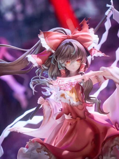 Close-up of Reimu Hakurei with orange-red eyes, a ragged red hair bow, sweeping brown hair and a pink talisman held near her face.