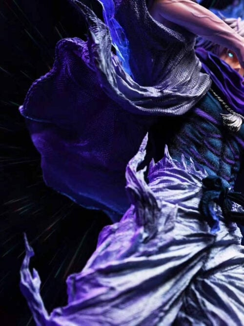 Low-angle view of the Satoru Gojo statue highlighting the textured white haori, dark blue torso, knotted waist sash, wide white trousers, and translucent purple energy plumes.