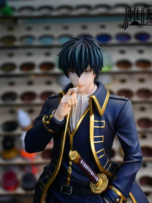 Front upper-body close-up of the Toushirou Hijikata statue showing the standard portrait raising a cigarette to his lips, white cravat, and gold-trimmed Shinsengumi coat