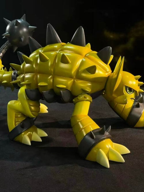 Front-right three-quarter view of LD Studio's Ankylomon figure showing the forward-angled horned head, segmented yellow carapace, dark grey flank spikes, spiked ankle cuffs, and raised tail club.