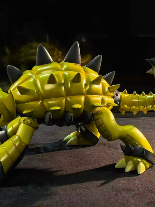 Left side profile of LD Studio's Ankylomon figure highlighting the full horizontal span from the lowered horned head and three-clawed feet across the yellow shell to the upward-curving tail and grey spiked mace.