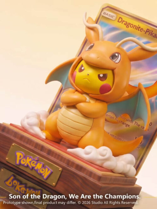 Angled close-up of Peak Studio Pikachu in a Dragonite costume with furrowed brow and crossed arms between cloud puffs on a wood base with a trading card backdrop.