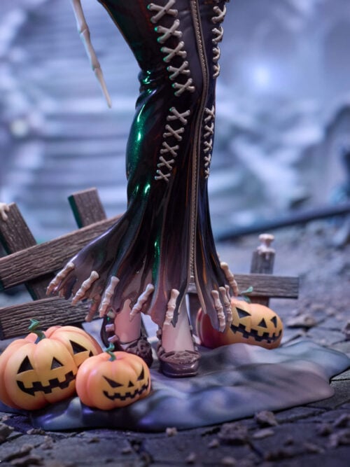 Close-up of the lower skirt with bone-tipped hem, skull-accented shoes, wooden fence posts with bone candles, and three jack-o'-lanterns on the display base