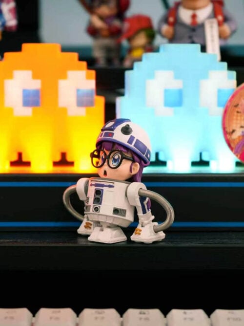 TOR Studio Arale Series Vol. 28 WCF-scale figure standing on a black desk riser in front of illuminated pixel ghost lights and a round Arale badge, angled slightly to the left.