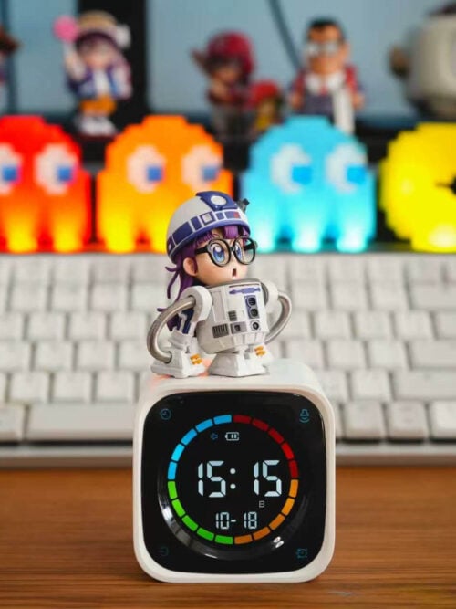 TOR Studio Arale Series Vol. 28 WCF-scale figure of Arale Norimaki in a white-and-blue astromech droid shell with coiled silver hose arms, standing on a white digital desk clock in front of a keyboard and pixel ghost lights.