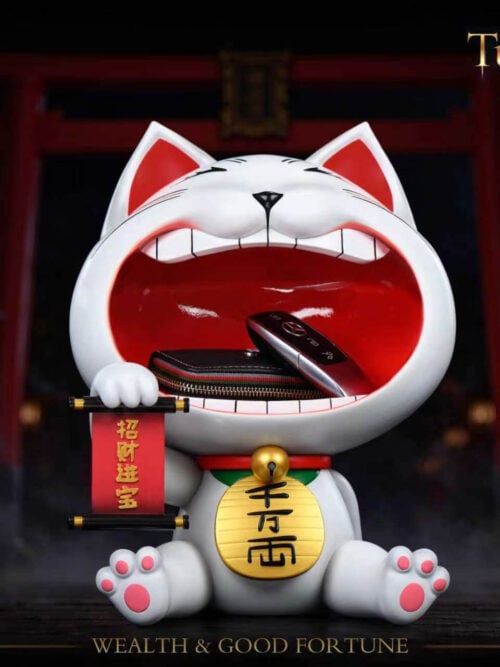 Front view of Stone Custom Studio Turbo Granny maneki-neko entryway display piece holding a wallet and car key fob inside the open mouth against a shrine background.