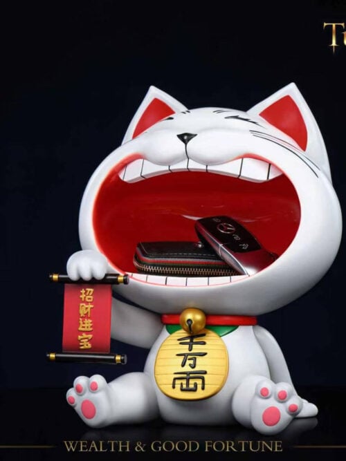 Angled view of Stone Custom Studio Turbo Granny maneki-neko entryway display piece holding a wallet and car key fob inside the open mouth on a black background.