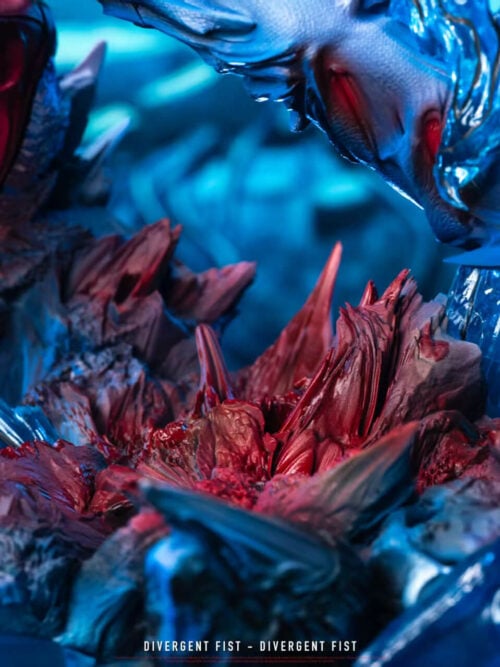 Close-up of the shattered base showing jagged red and gray debris textures and the red sneakers of the Yuji Itadori statue.
