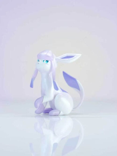 White and lavender Glaceon figure seated with long head flaps and a curved upright tail against a pale purple background.