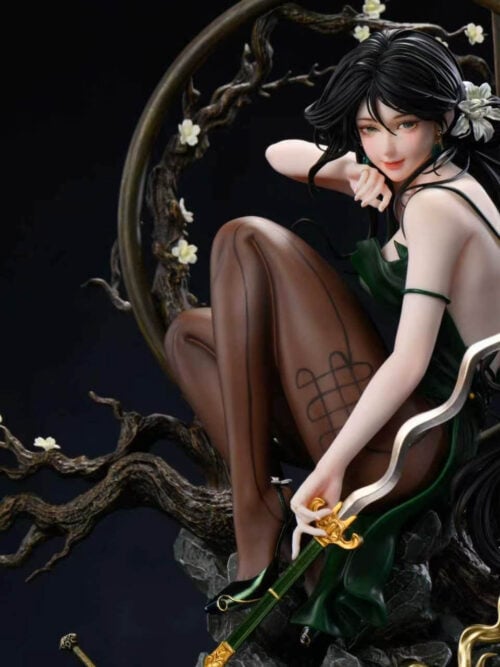 Close view of Tianyi He's seated pose, patterned brown stockings, green dress and gold-colored sword guard among flowering branches.