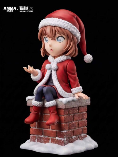 Front three-quarter view of Ai Haibara in a Santa hat, red coat and boots, seated with one palm raised on a snow-covered brick chimney.