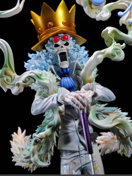 Close-up of Brook's gold-colored crown hat, red heart-shaped glasses, pale blue hair and skeletal hands resting on a purple cane.