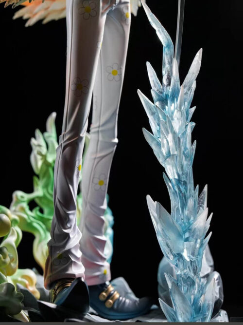 Detail of Brook's white flower-patterned trousers and dark shoes beside tall blue ice-like spikes.