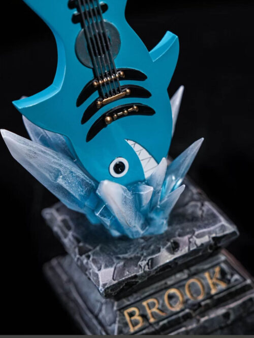 Close-up of Brook's blue shark-shaped guitar bonus among ice-like spikes on a stone-effect stand labeled BROOK.